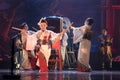 Group of actresses in traditional white and red kimono and fox masks dance and drum a big taiko