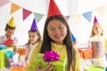 Group of adorable kids having fun at birthday party asian on the front