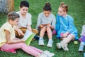 group of adorable pupils spending time together on grass