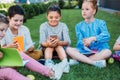 group of adorable schoolchildren spending time together on grass