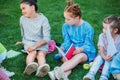 group of adorable schoolgirls spending time together on grass