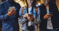 Group adult hipsters using in hands mobile phone closeup, street online wi-fi internet concept, bloggers friends together pointing Royalty Free Stock Photo