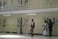 men in prison cell block with doors open and numbers hanging Royalty Free Stock Photo