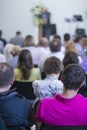 Group of Adult Professionals Listening to the Lecturer Speaking on Stage