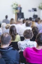 Group of Adult Professionals Listening to the Lecturer Speaking on Stage