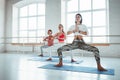 Group of adult women doing yoga exercises together in fitness class. Active people practice yoga poses on mat