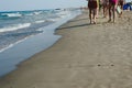 Group of adult women in swimsuits walking on a sunny beach at noon in the mediterranean Royalty Free Stock Photo