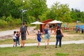 Group of adults and children are walking down a picturesque nature trail surrounded by lush trees