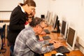 Group of adults learning computer skills. Intergenerational tran Royalty Free Stock Photo