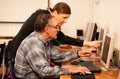 Group of adults learning computer skills. Intergenerational tran Royalty Free Stock Photo