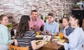 Group of adults and teenagers spending time in cafe Royalty Free Stock Photo