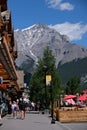 Group of adults walking down a street with towering mountains in the background, Banff Alberta