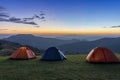Group of adventurer tents during overnight camping site at the beautiful scenic sunset view point over layer of mountain for Royalty Free Stock Photo