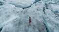 Moody Aerial View Of Girl Walking On Ice River