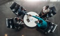 Group of African business people sitting and discussing statistics during a sit down meeting taking from above. Two colleagues are