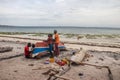 Group of African people fixing and maintaining fisherman\'s colorful wooden boat, at the shore of Indian Ocean