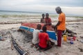 Group of African people fixing and maintaining fisherman\'s colorful wooden boat, at the shore of Indian Ocean Royalty Free Stock Photo