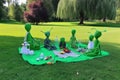 group of aliens picnicking on a lush green lawn