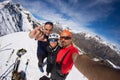 Group of alpinists selfie on mountain top. Scenic high altitude background on snow capped Alps, sunny day.