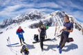 Group of alpinists selfie on mountain top. Scenic high altitude background on snow capped Alps, sunny day.