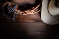 American Cowboy Items incluing a lasso spurs and a traditional straw hat on a wood plank background Royalty Free Stock Photo