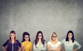 Group of angry negative young women looking at camera while standing against concrete wall background Royalty Free Stock Photo