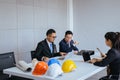 Group of architect asian people meeting and working communicating while sitting at room office desk together