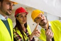 Group of architect watching some details on blueprints at construction site Royalty Free Stock Photo