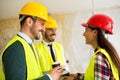 Group of architect watching some details on blueprints at construction site Royalty Free Stock Photo