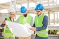 Group of architects or business partners discussing floor plans on a construction site Royalty Free Stock Photo