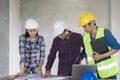 Group of architects look at blueprint and discussing project construction Royalty Free Stock Photo