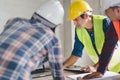 Group of architects look at blueprint and discussing project construction Royalty Free Stock Photo