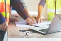 Group of architects look at blueprint and discussing project construction. selective on glasses on the table Royalty Free Stock Photo