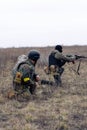 Group of armed Ukrainian soldiers aims in enemy in steppe