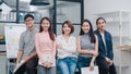 Group of Asia young creative people in smart casual wear looking at camera and smiling in creative office workplace. Diverse Asian