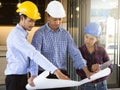 Group of asian architect/engineer/foreman explaining progress of work with client/investor in the blueprint in construction site