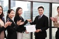 Group of Asian business corporation team celebrating together in the meeting room with CEO given certificate to the branch manager