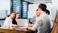 Group of Asian business people work together in team brainstorm discussion using laptop computer in office