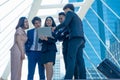 Group of asian business team woman and men discuss and meeting,with computer laptop standing in street tower building outside, Royalty Free Stock Photo