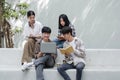 Group of Asian college student reading books and tutoring special class for exam on grass field at outdoors. Happiness Royalty Free Stock Photo