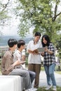 Group of Asian college student reading books and tutoring special class for exam on grass field at outdoors. Happiness Royalty Free Stock Photo