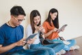 Group of Asian college student using tablet and mobile phone outside classroom. Happiness and Education learning concept. Back to Royalty Free Stock Photo