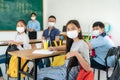 Group of Asian elementary school students and teacher wearing hygienic mask to prevent the outbreak of Covid 19 in classroom while Royalty Free Stock Photo