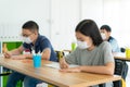 Group of Asian elementary school students wearing hygienic mask in classroom and smiling to be happy while back to school reopen Royalty Free Stock Photo