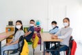 Group of Asian elementary school students wearing hygienic mask in classroom and smiling to be happy while back to school reopen Royalty Free Stock Photo