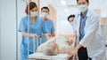 Group of Asian emergency doctor and nurse team wear face mask, push emergency stretcher, transport senior patient in hospital