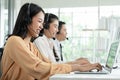 Group of Asian employee work in telemarketing customer service teams. Young operator woman working with headset smiling Royalty Free Stock Photo