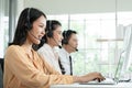 Group of Asian employee work in telemarketing customer service teams. Young operator woman working with headset smiling Royalty Free Stock Photo