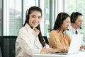 Group of Asian employee work in telemarketing customer service teams. Young operator woman working with headset smiling Royalty Free Stock Photo