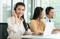 Group of Asian employee work in telemarketing customer service teams. Young operator woman working with headset smiling Royalty Free Stock Photo